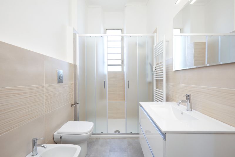Renovated bathroom with frosted sliding shower screen, wall-hung toilet and floating vanity