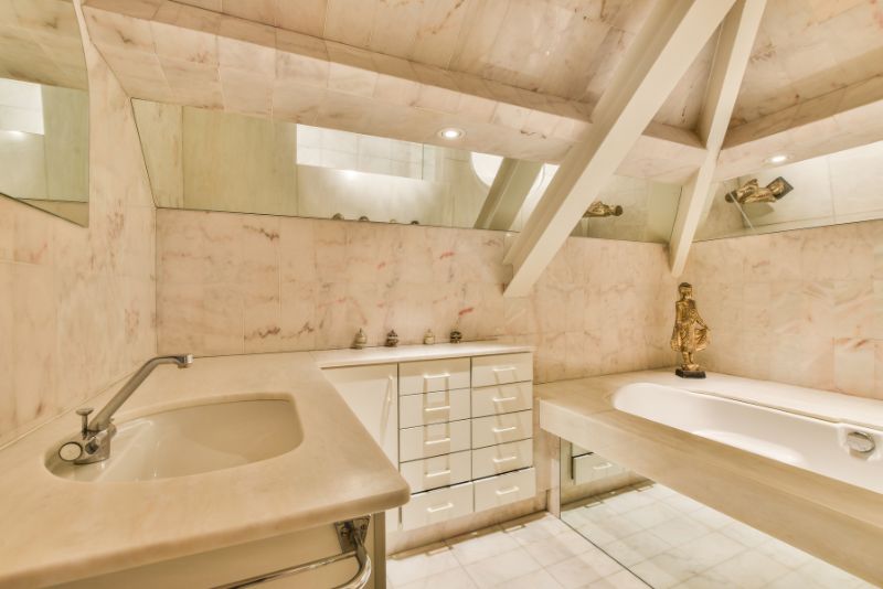 Marble ensuite bathroom with a freestanding tub and decorative sink fitting